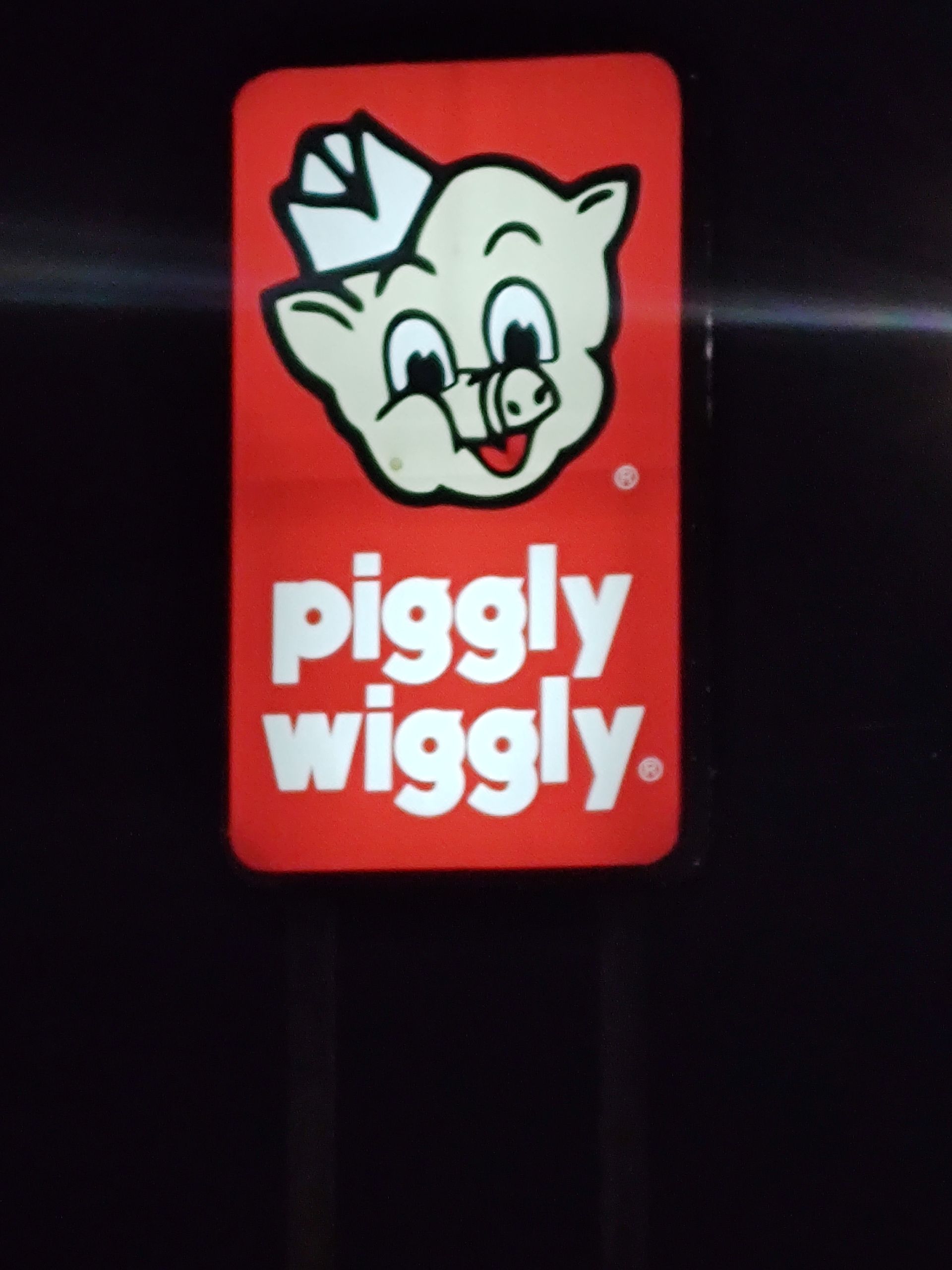 A sign that says piggly wiggly on it
