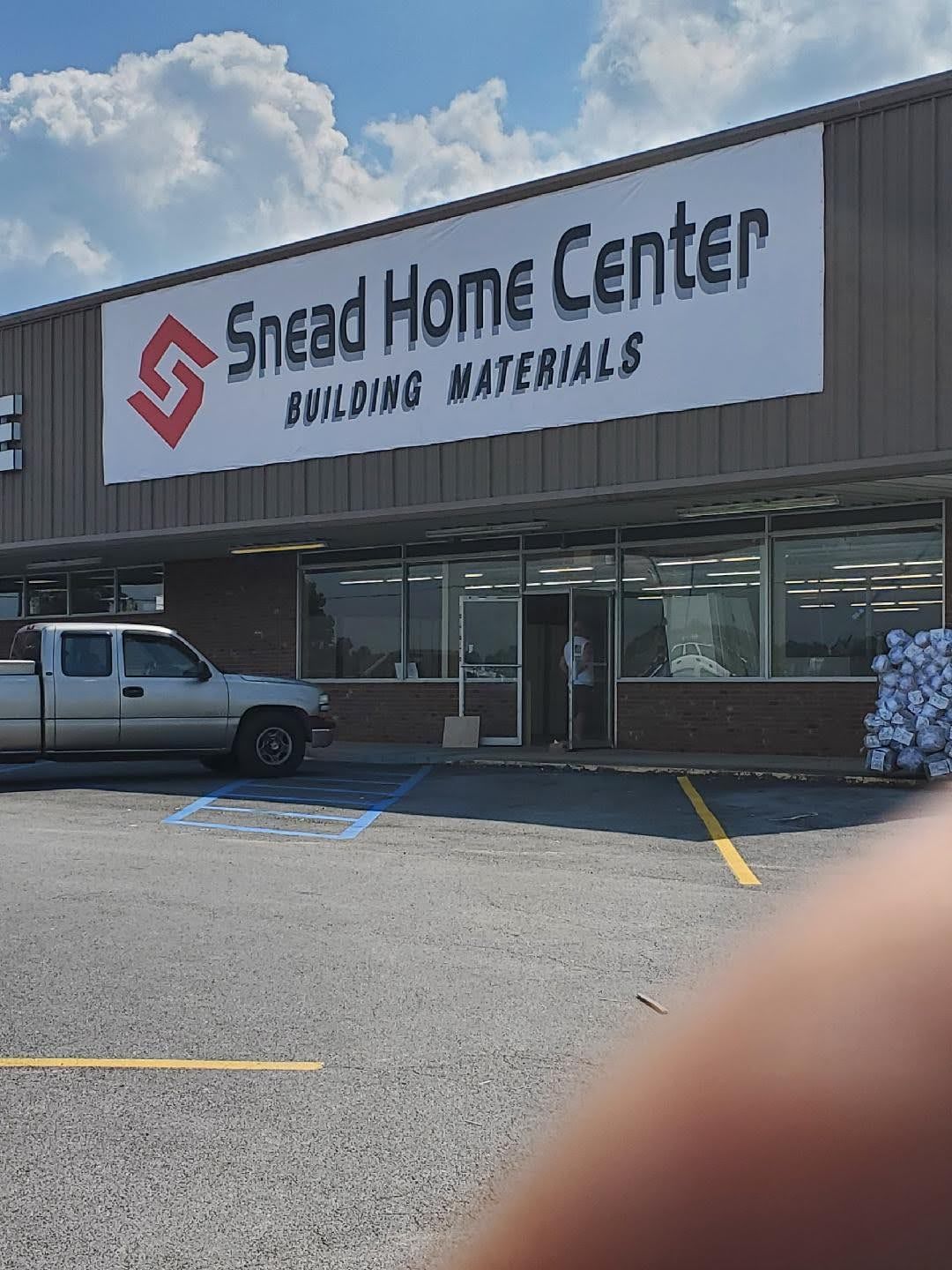 A truck is parked in front of a snead home center building materials store