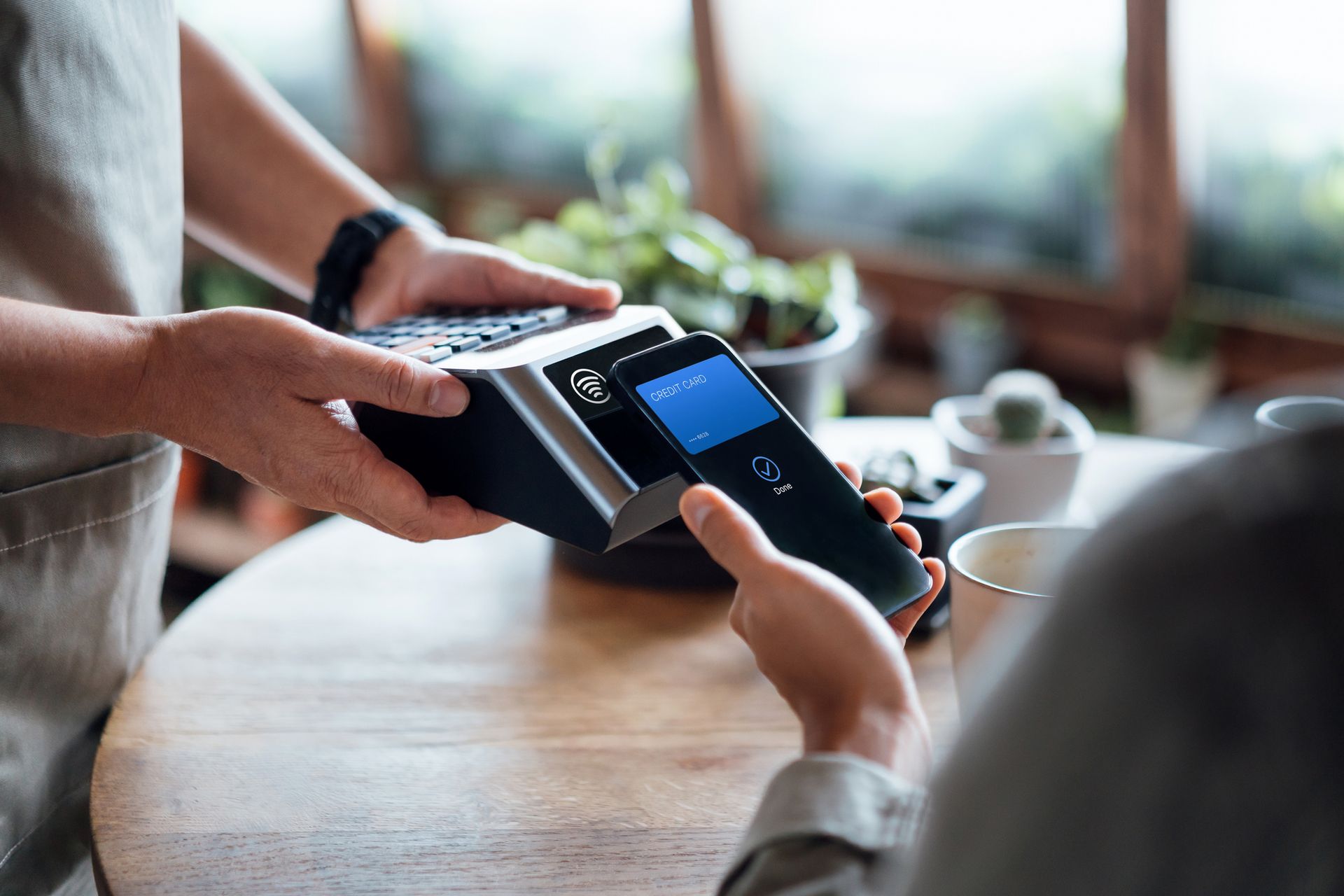 A hand paying a bill, using a contactless payment on a smartphone, showcasing POS equipment A hand paying a bill, using a contactless payment on a smartphone, showcasing POS equipment