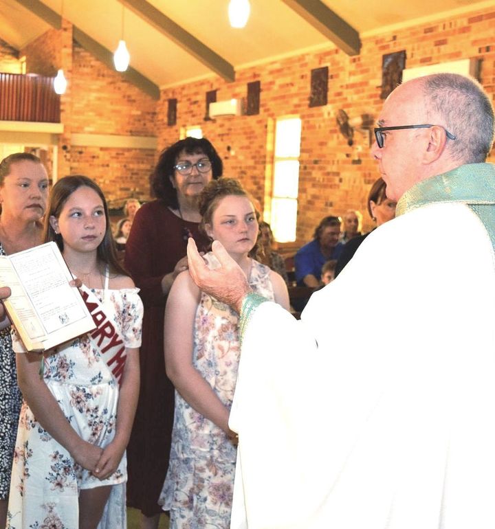 A woman wearing a sash that says