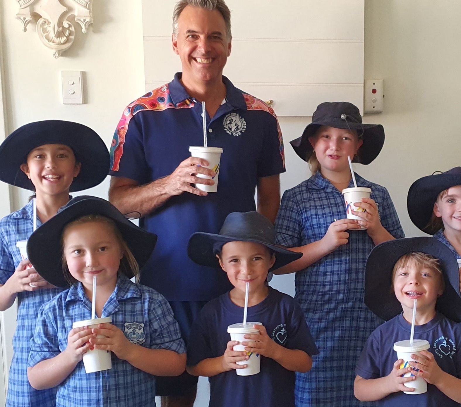 A group of children are posing for a picture with straws in their cups