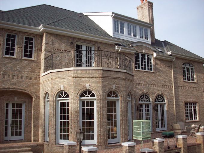 A man is cleaning a brick wall with a broom.