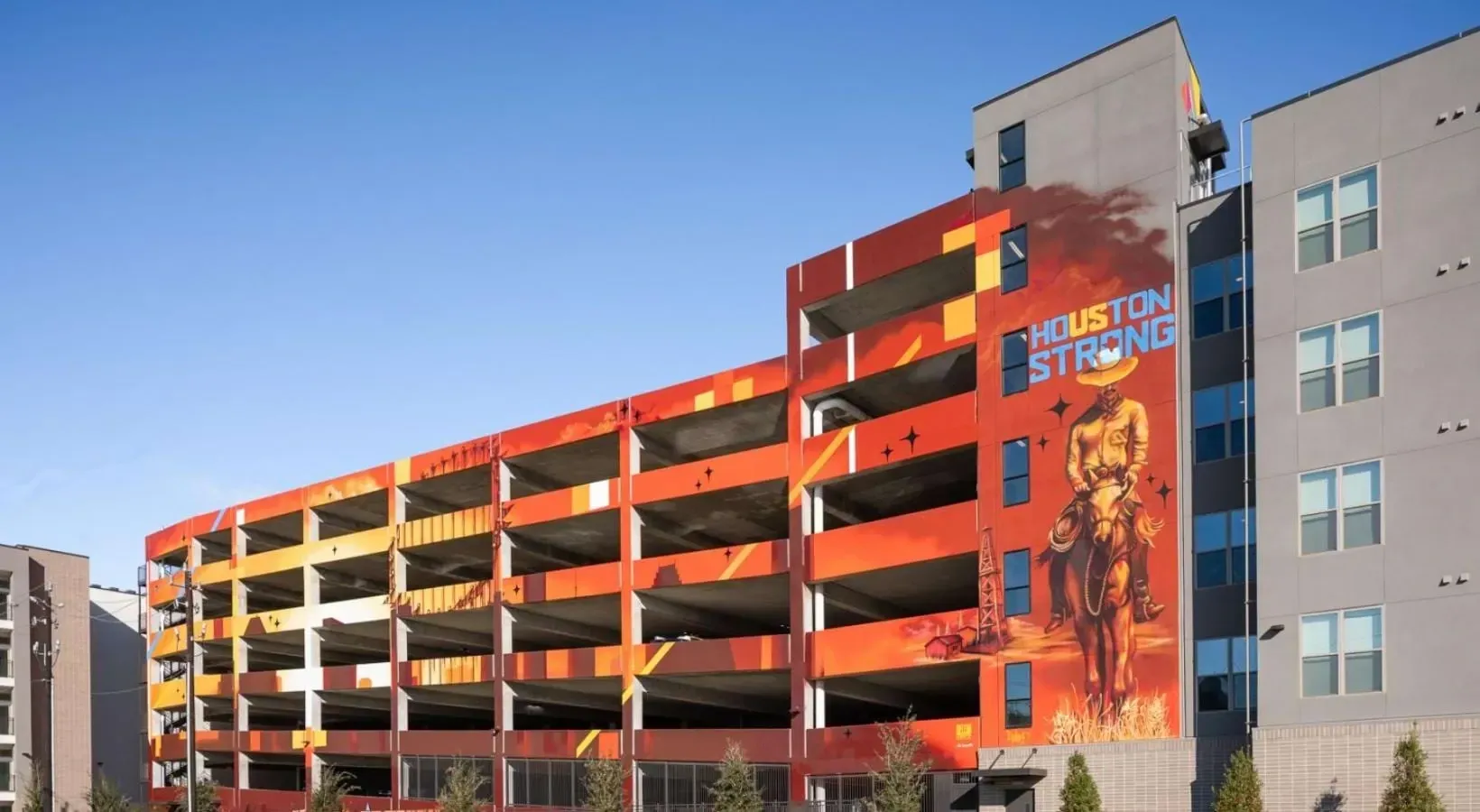 Parking garage with a large mural of a cowboy on a horse and the words 