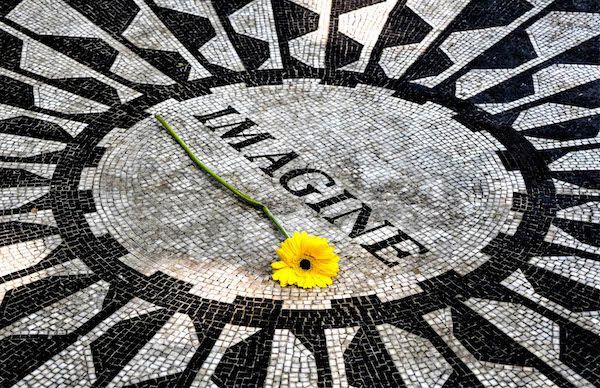 A yellow flower is sitting in the middle of a mosaic.