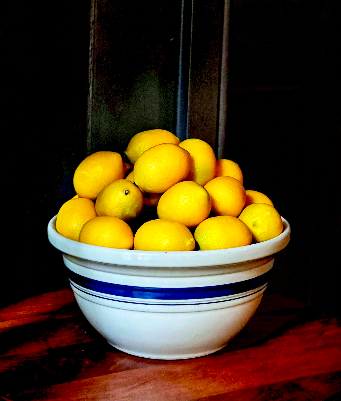 A bowl of lemons on a wooden table