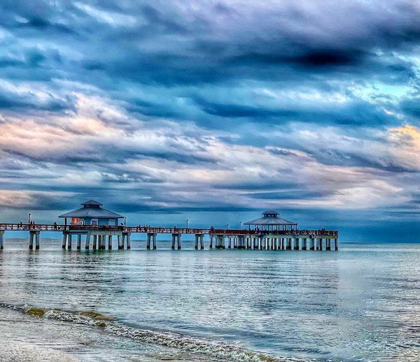 There is a pier in the middle of the ocean.