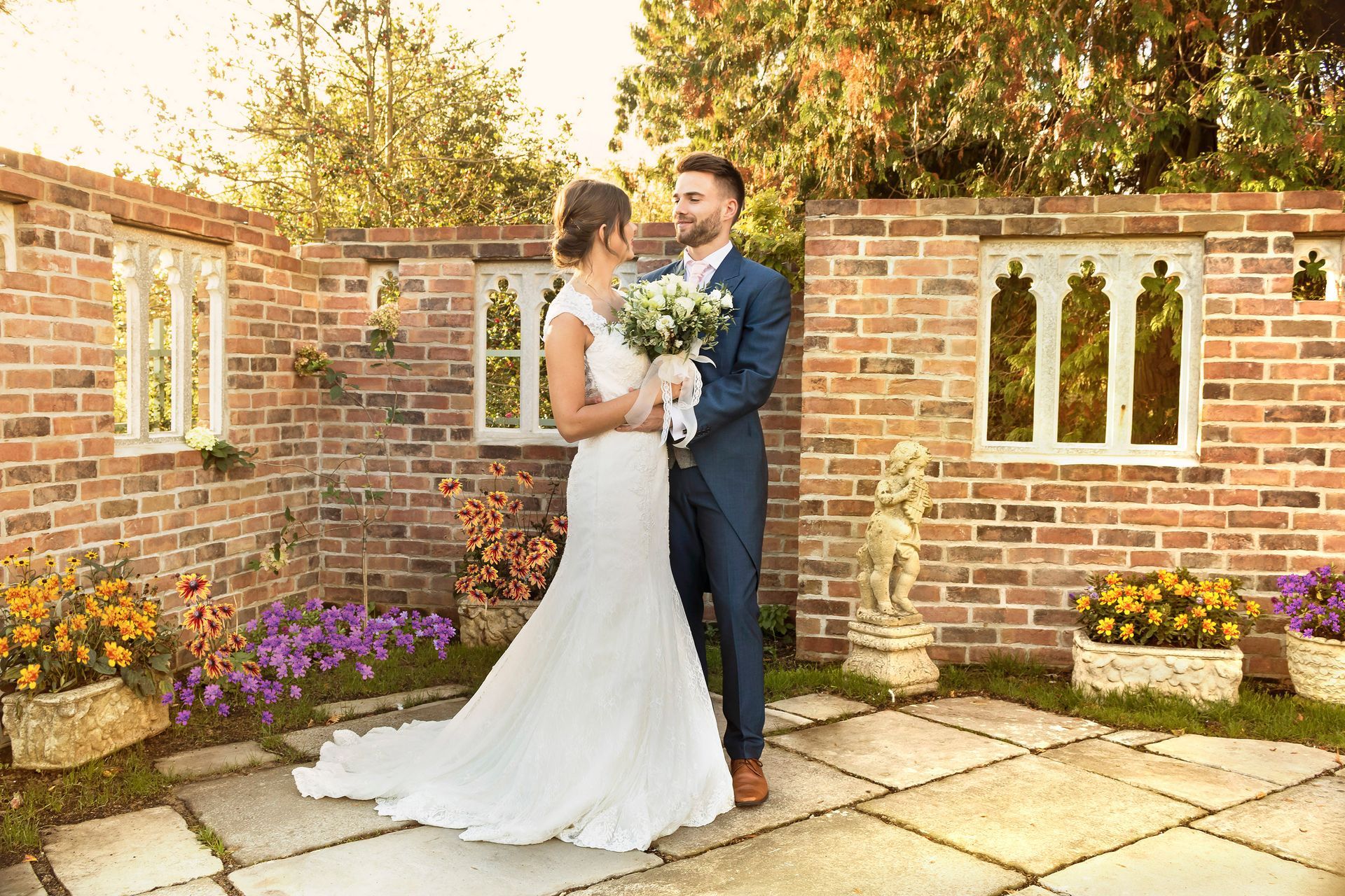 Bride and Groom posing Infront of the wedding folly wall in Ilminster, Somerset
