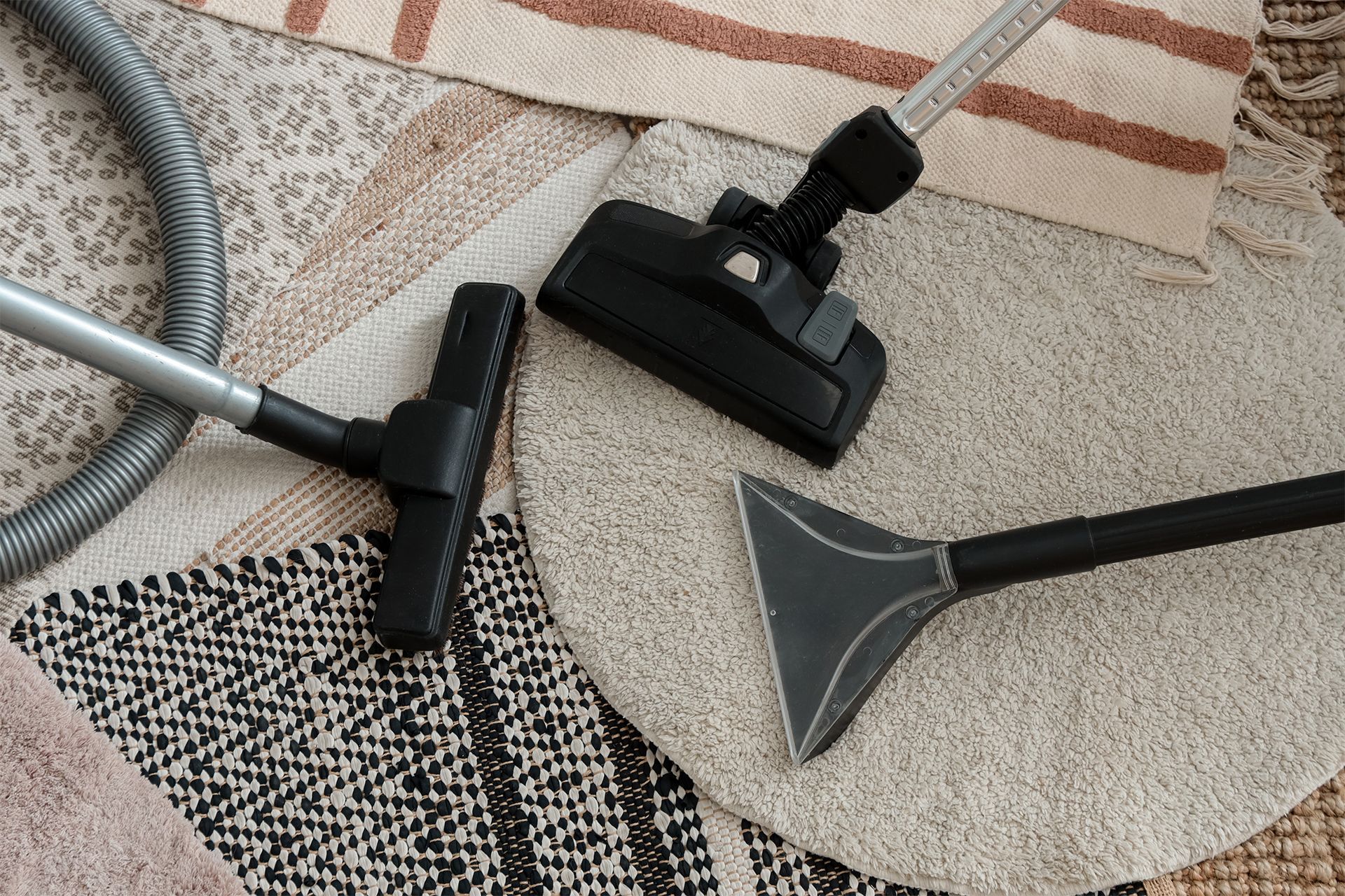 Vacuum cleaner attachments on various patterned rugs.