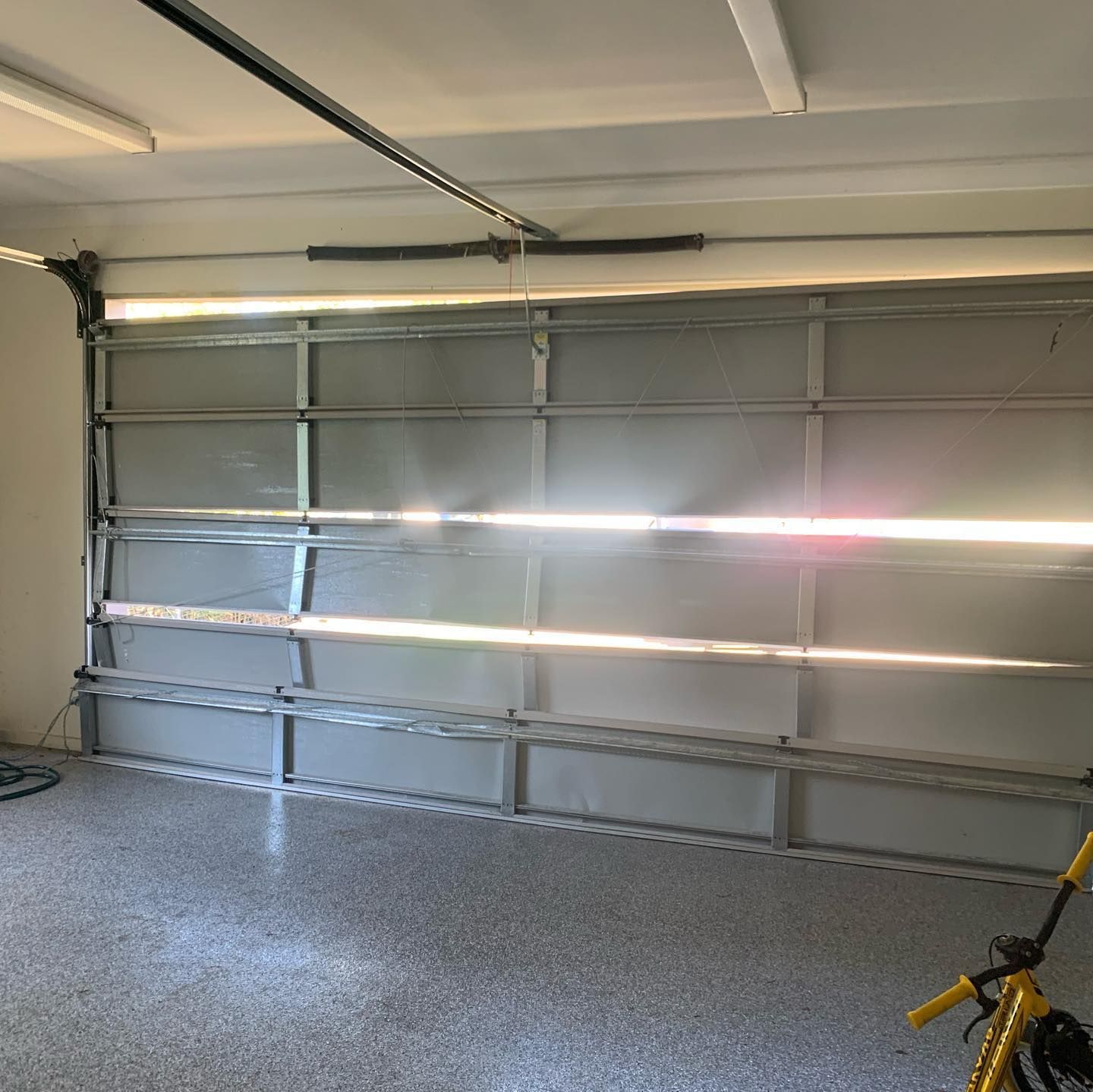 A bicycle is parked in a garage next to a garage door.