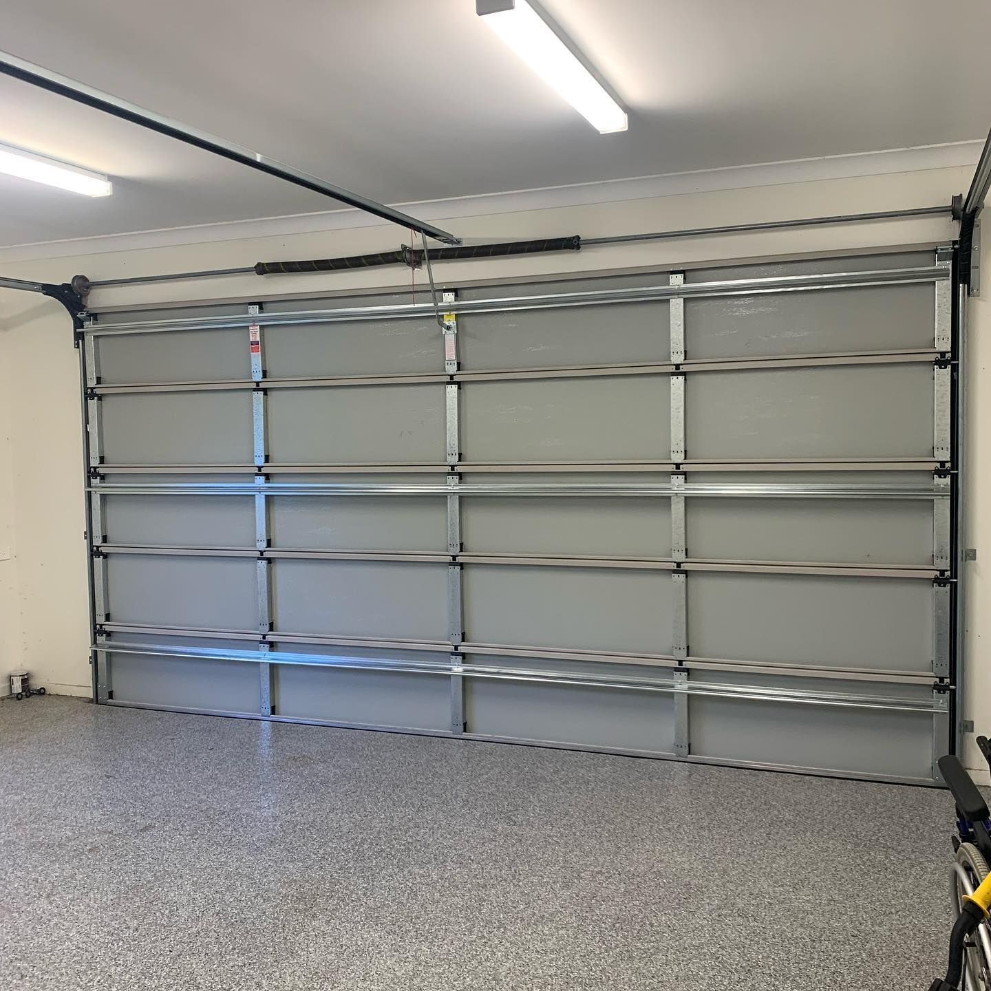 A garage with a large garage door and a concrete floor.