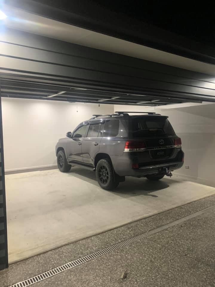 A suv is parked in a garage at night.