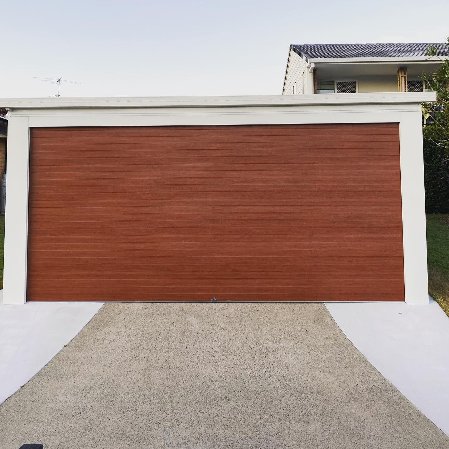 A red garage door is sitting next to a white wall.