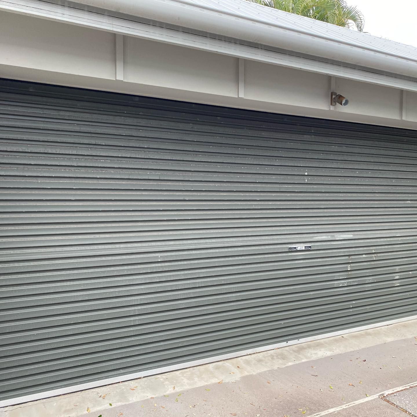 A close up of a garage door with a white roof.