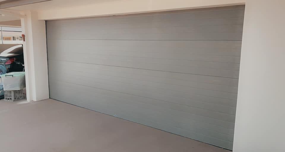 A car is parked in a garage next to a garage door.