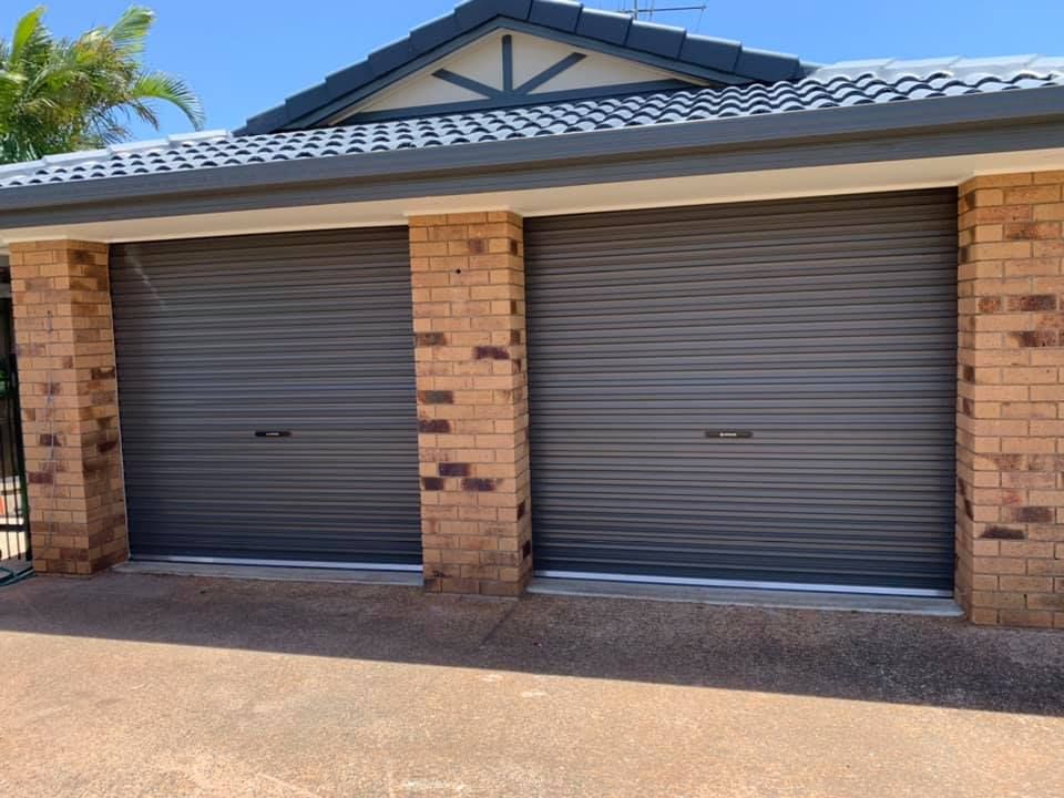 There are two garage doors on the side of a house.