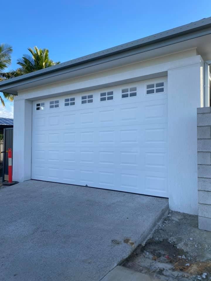 A white garage door with a lot of windows on it