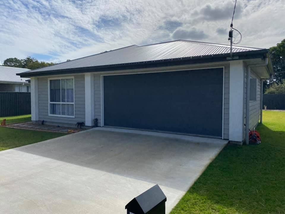 A house with a garage door and a mailbox in front of it.