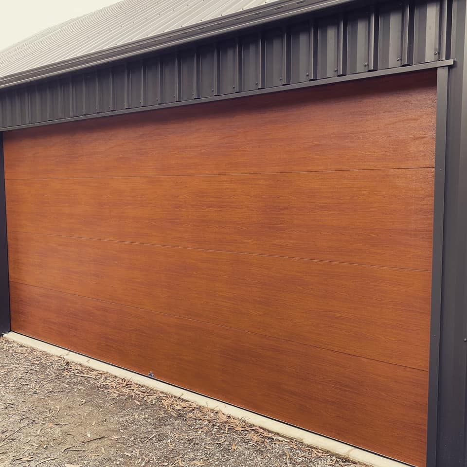 A garage door with a wooden finish and a black frame.