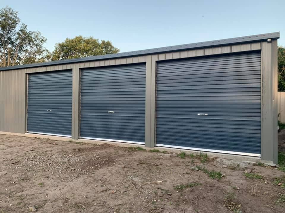 A row of garage doors sitting on top of a dirt field.
