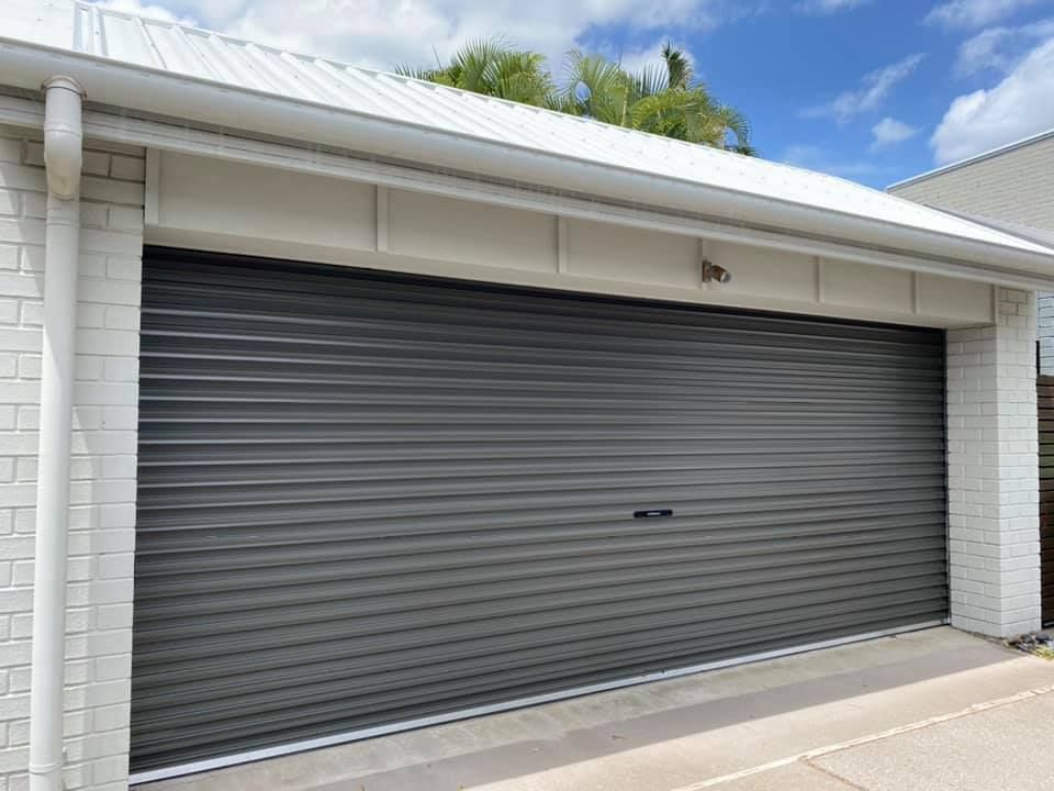 A garage with a gray garage door and a white roof.