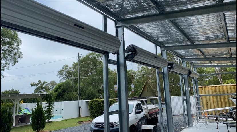 A white truck is parked under a canopy in a parking lot.