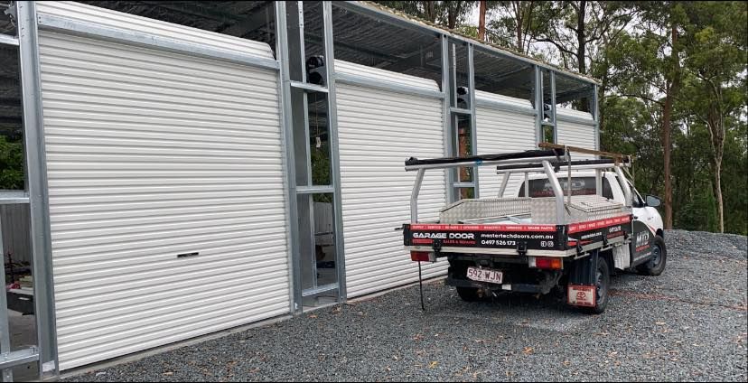 A truck is parked in front of a garage door.