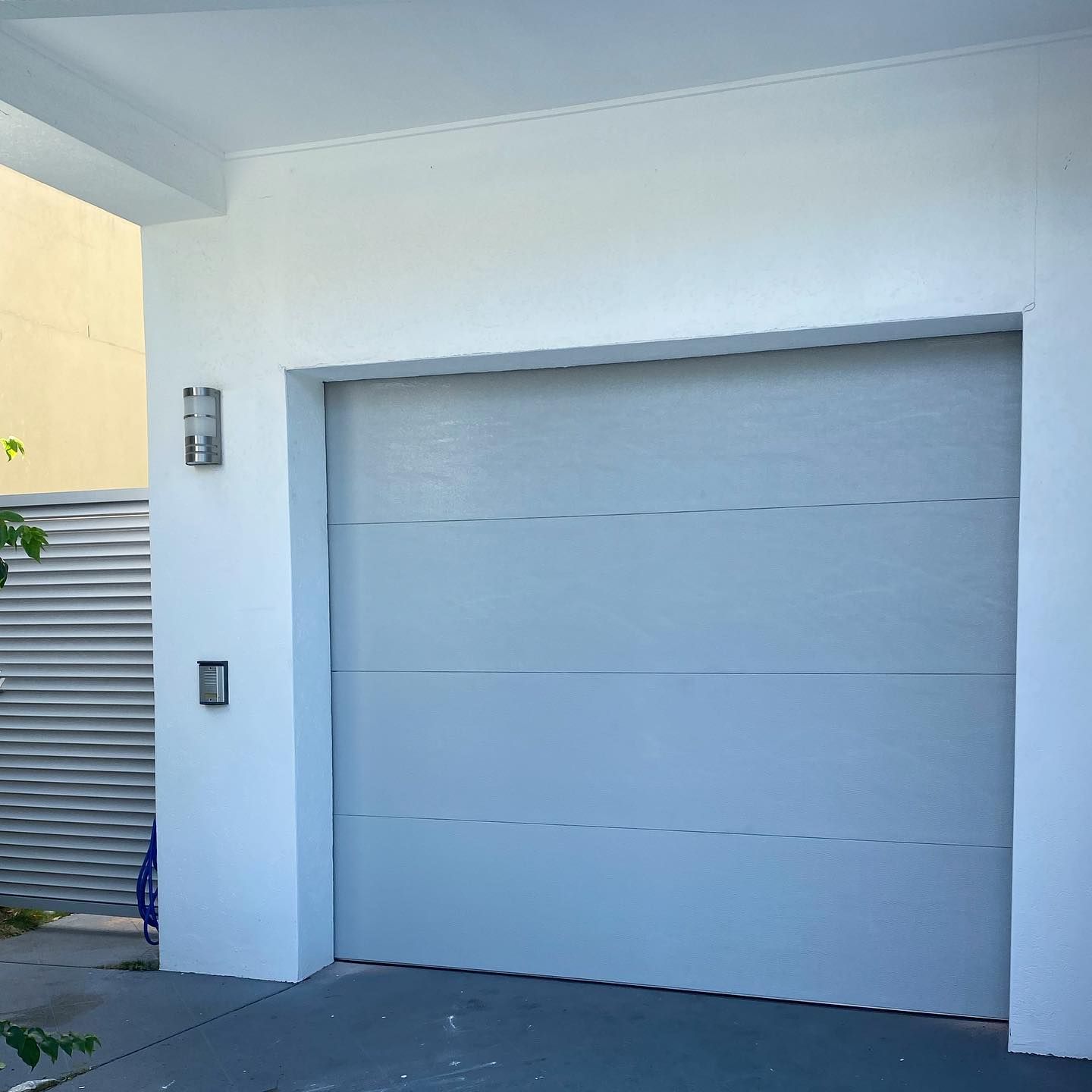 A white garage door with a light on the side of it