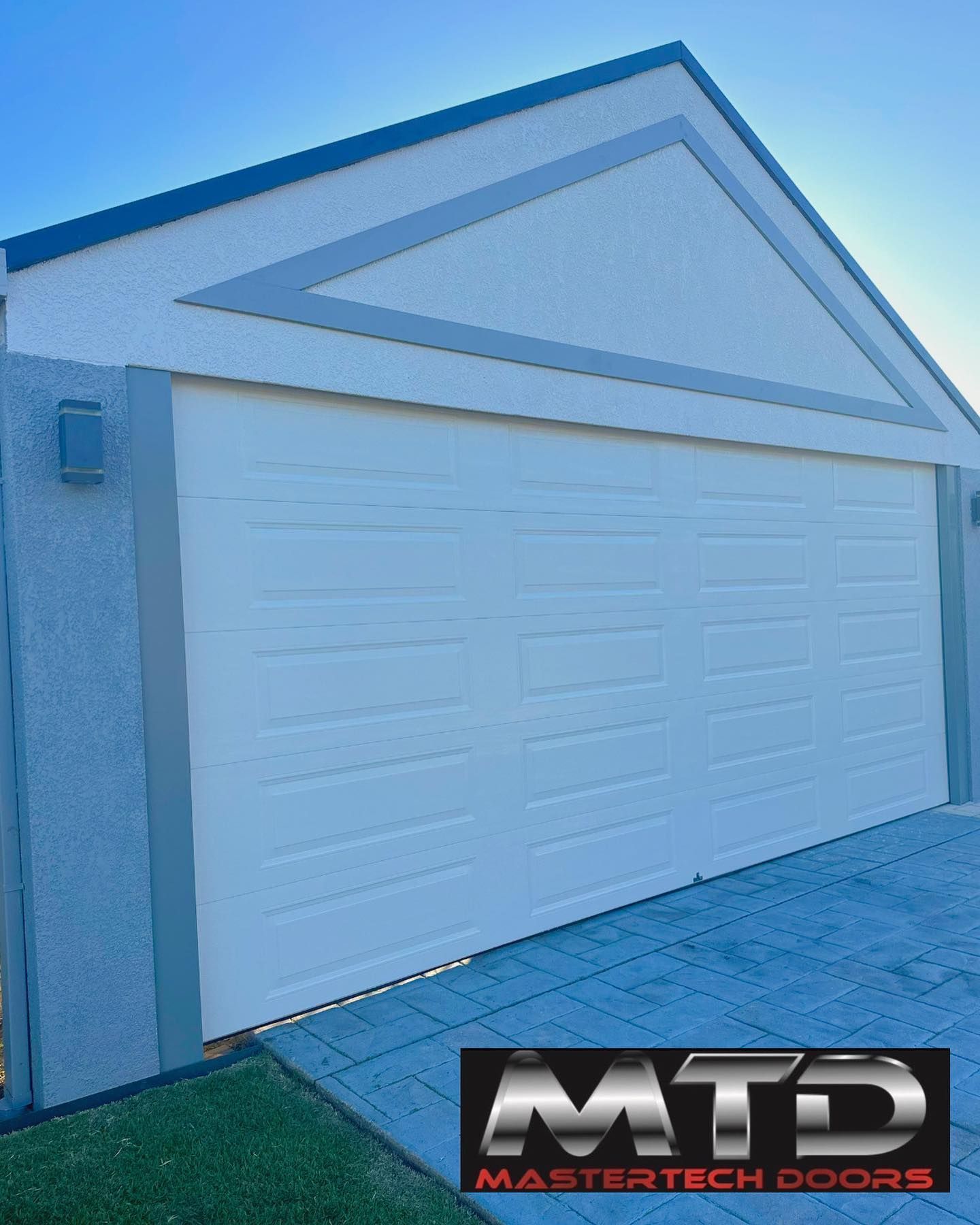 A white garage door with a mastertech doors logo on it