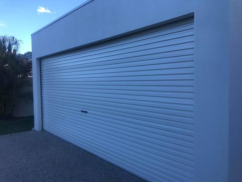 A white garage door is sitting on the side of a building.