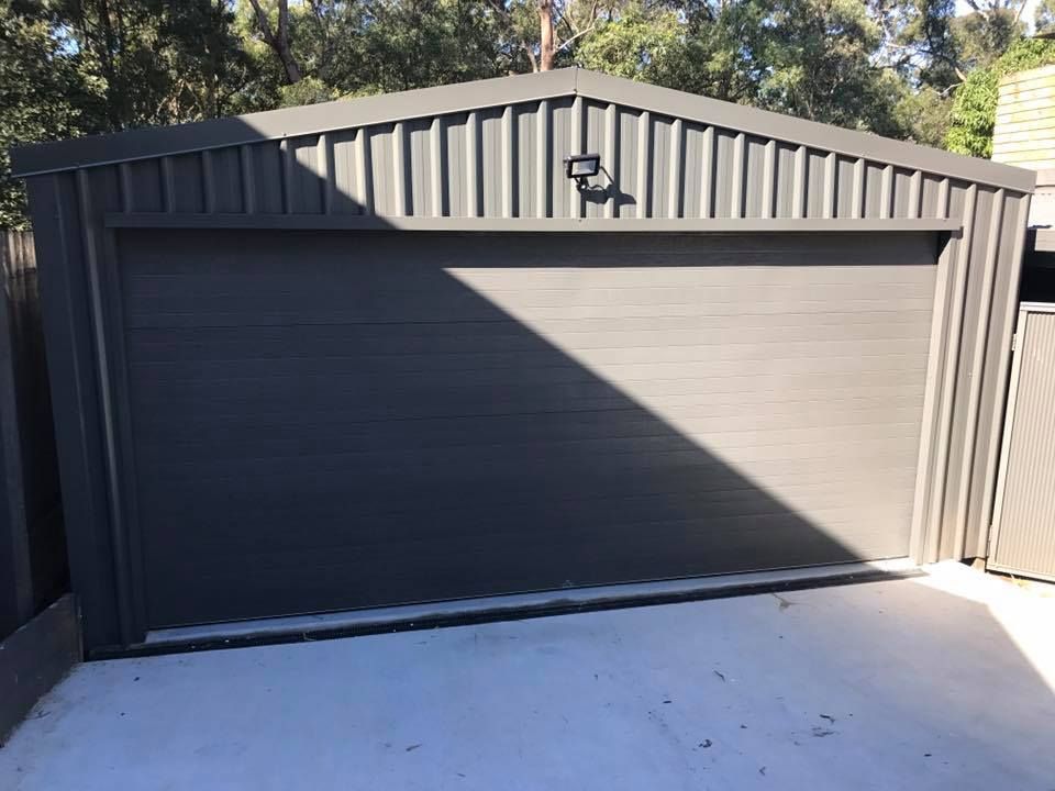 A gray garage door with a light on the side of it