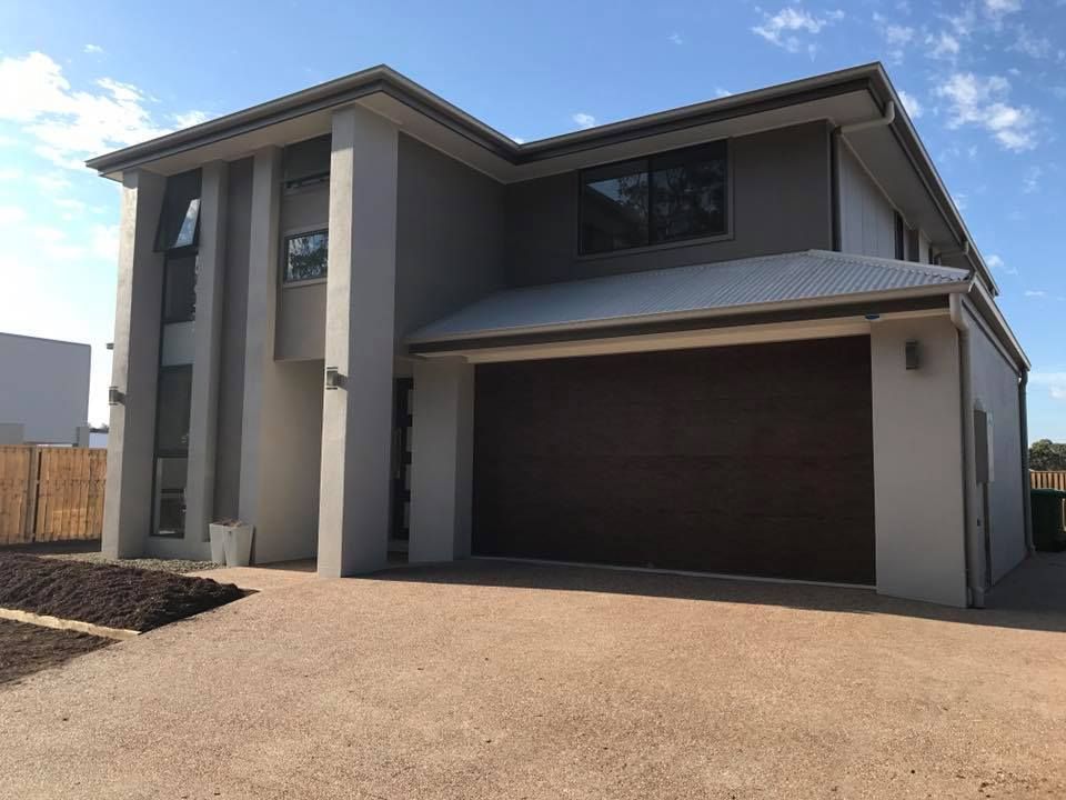 A large white house with a brown garage door