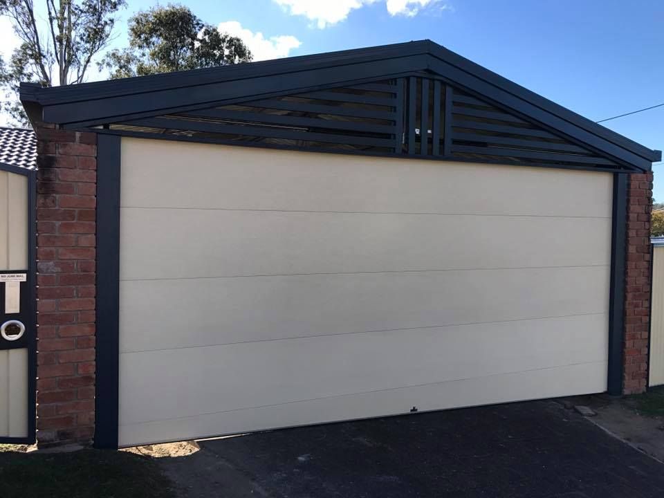 A garage with a white door and a black roof