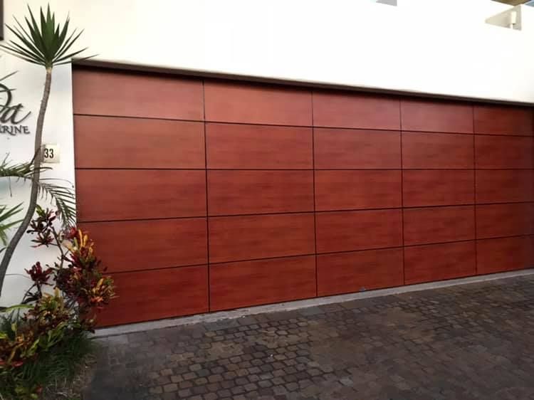 A large wooden garage door is sitting in front of a building.