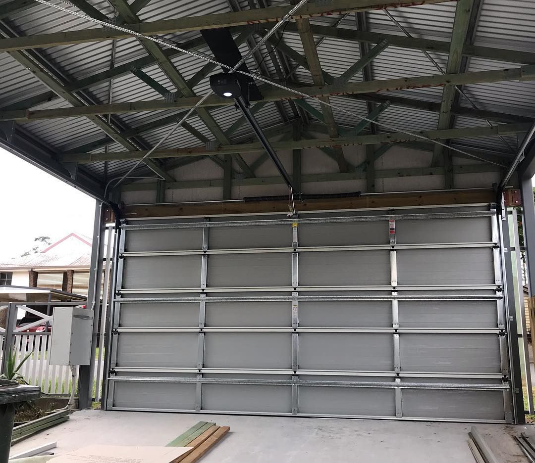 A garage door is being installed in a garage with a roof.