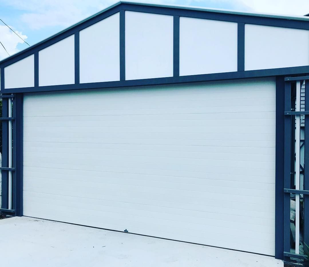 A white garage door with a black frame and a roof.