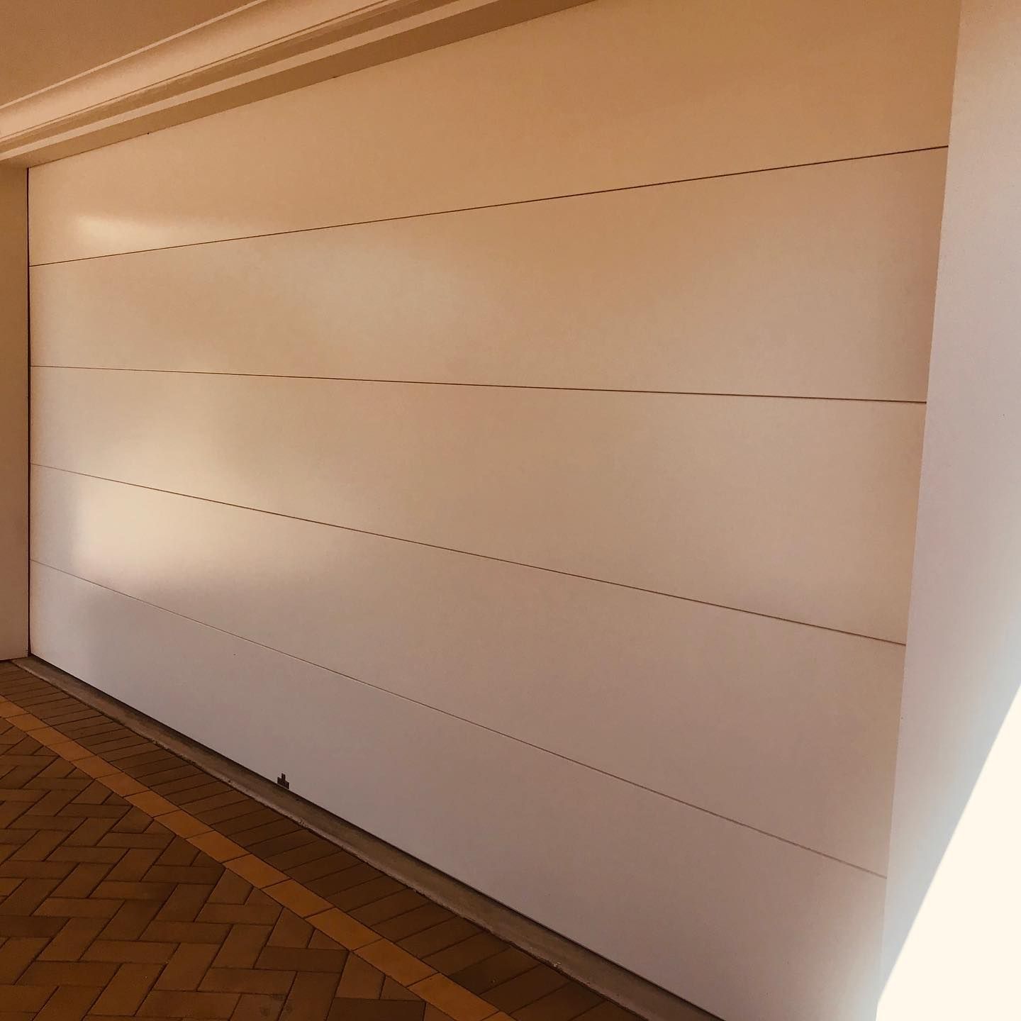 A white garage door with lines on it is in a room.