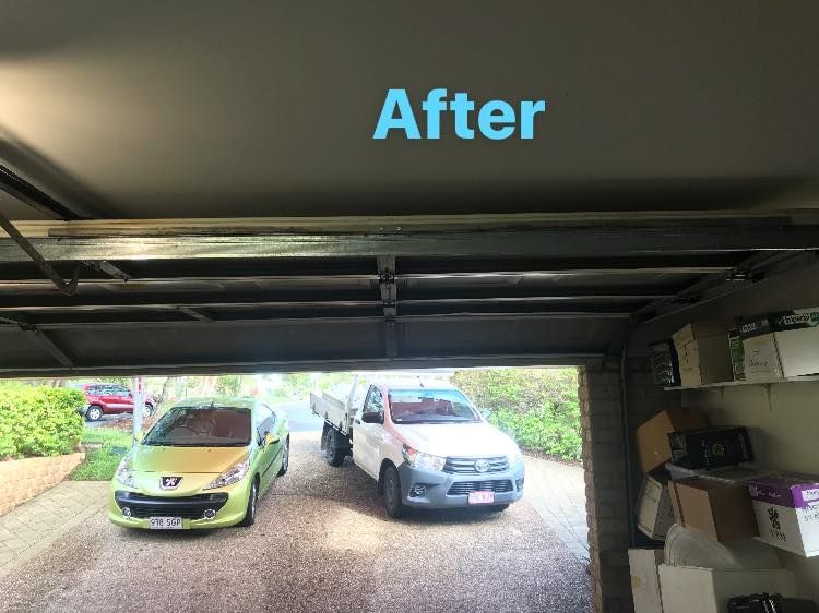 Two cars are parked in a garage with a sign that says after.