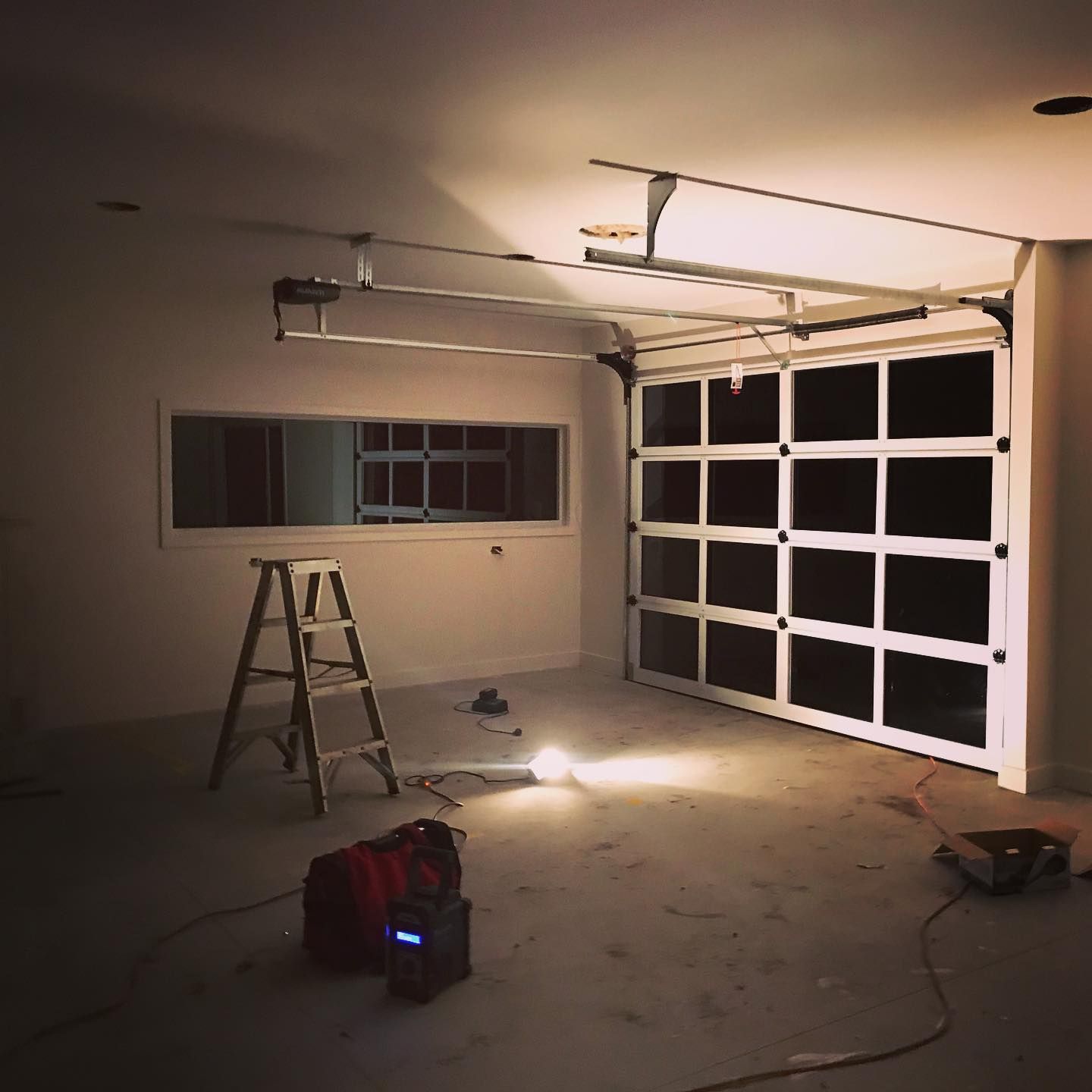 A garage with a ladder and a light on the floor