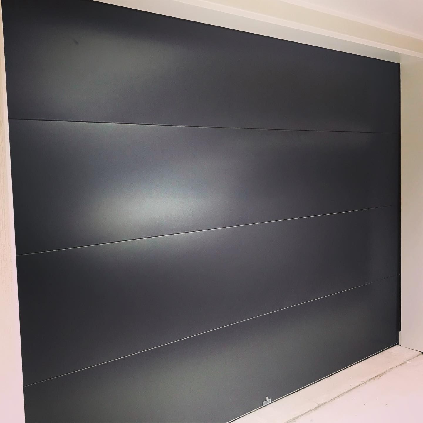 A black wall with a white border is sitting in a room.