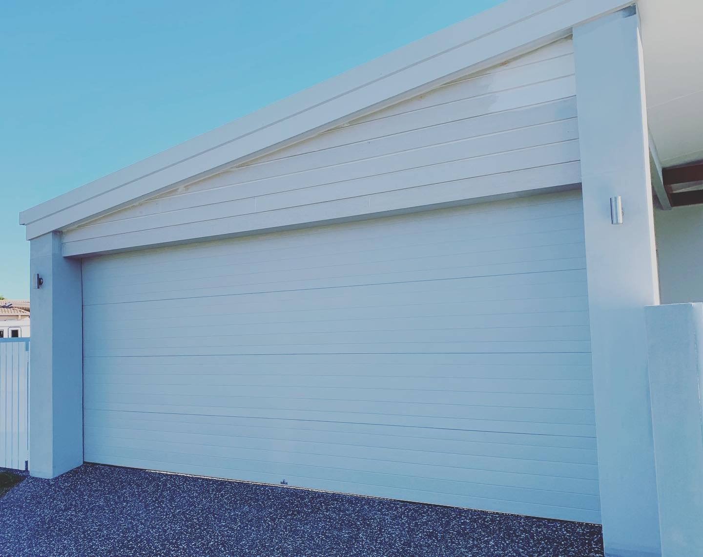 A white garage door with a blue sky in the background