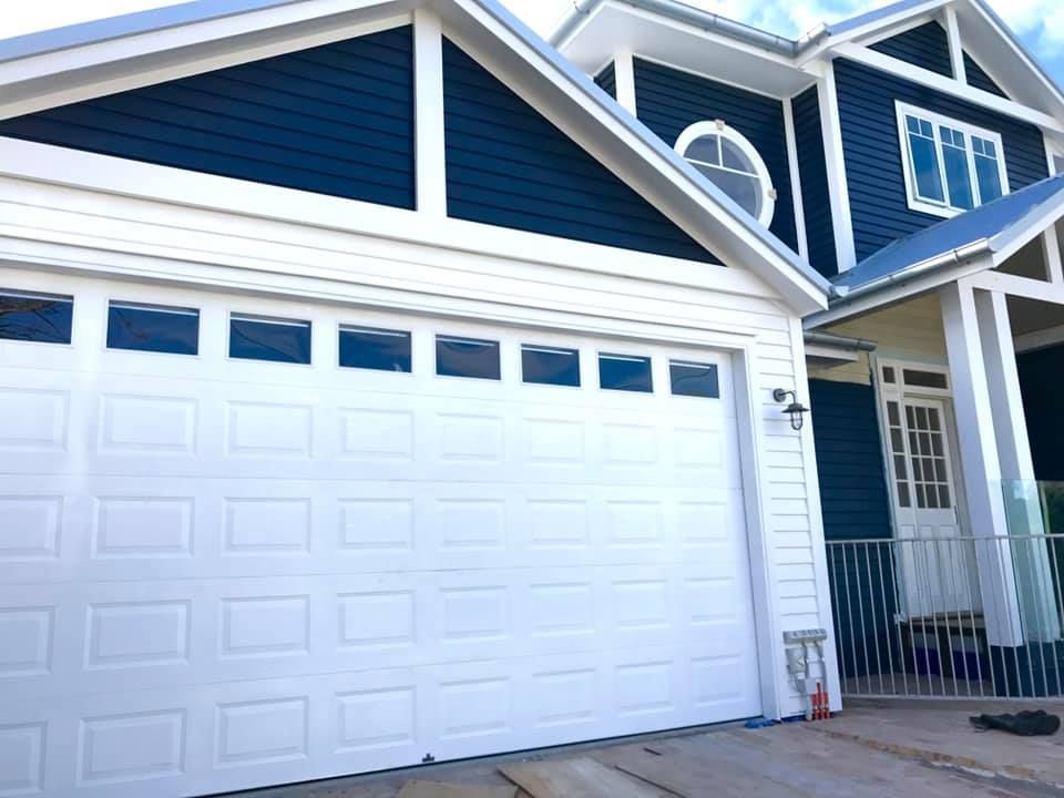 A blue and white house with a white garage door