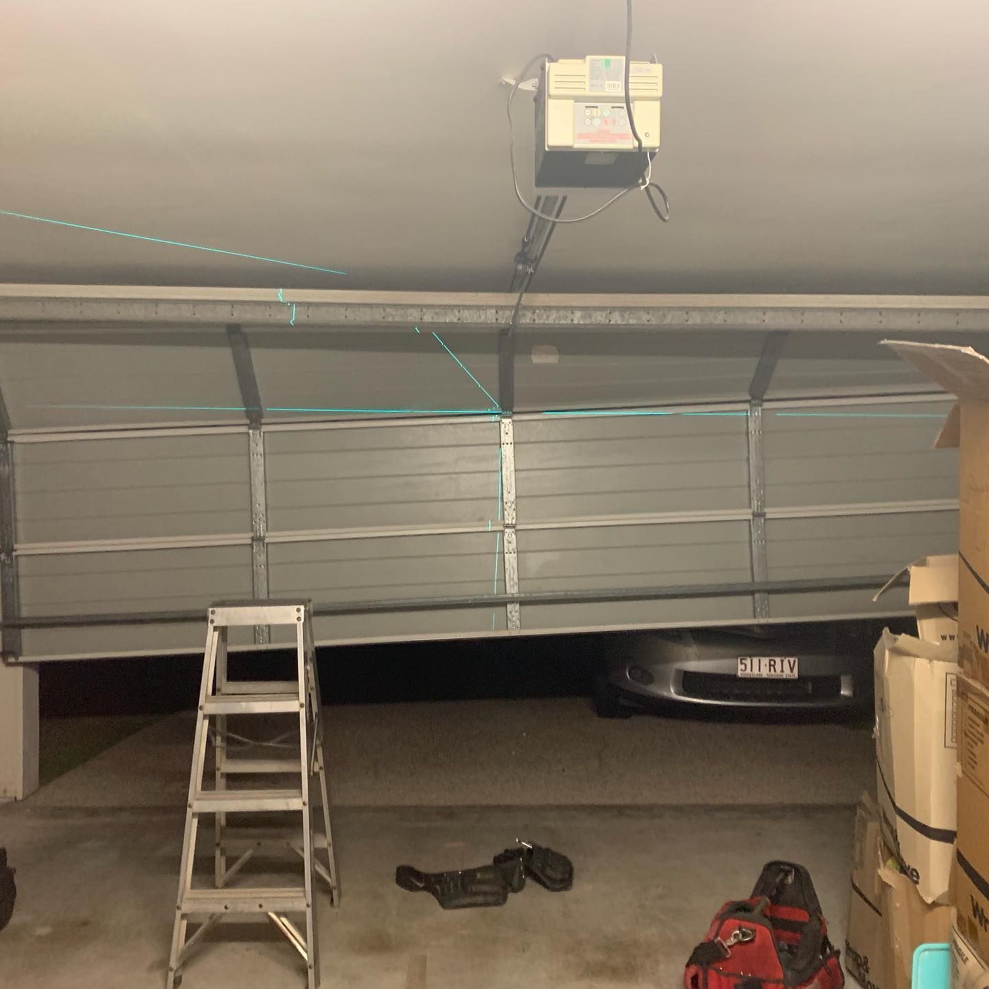 A garage with a ladder and a vacuum cleaner in it