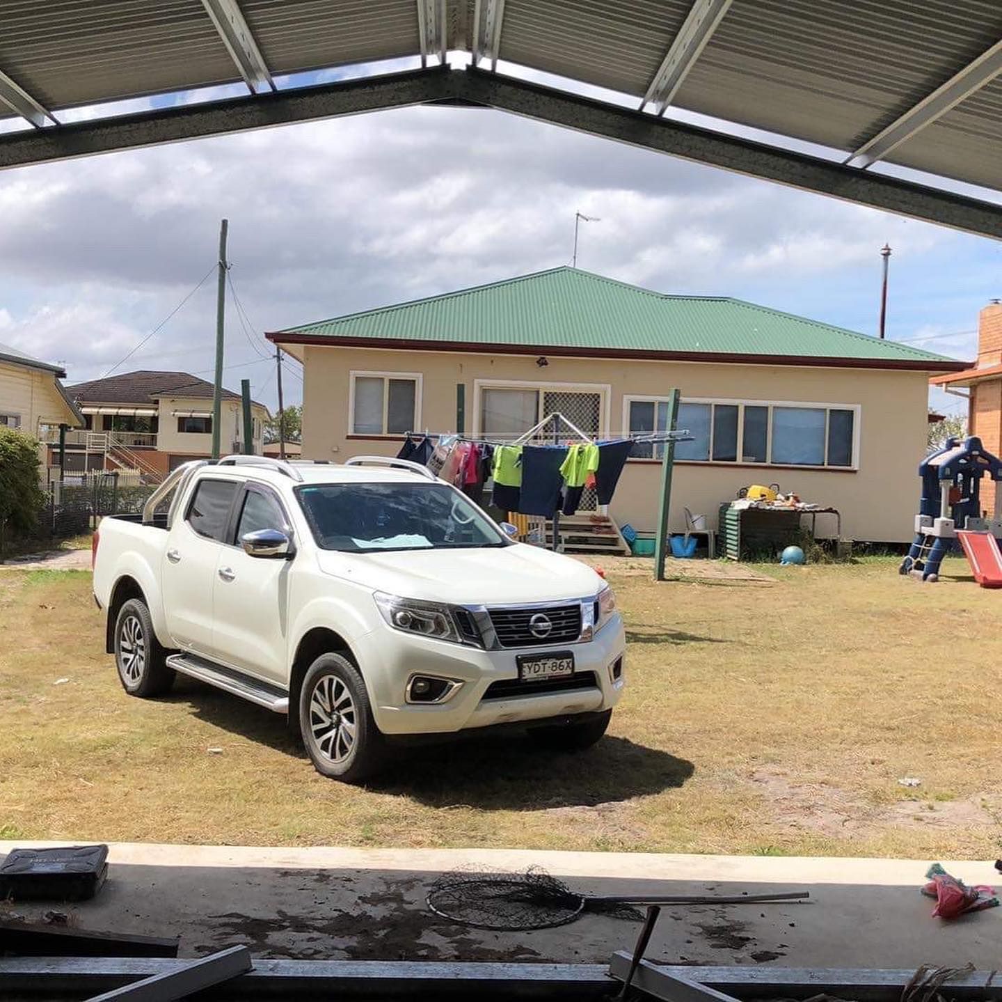 A white suv is parked in front of a house.