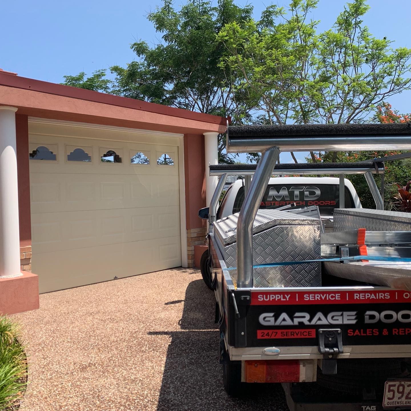 A garage door company truck is parked in front of a garage door