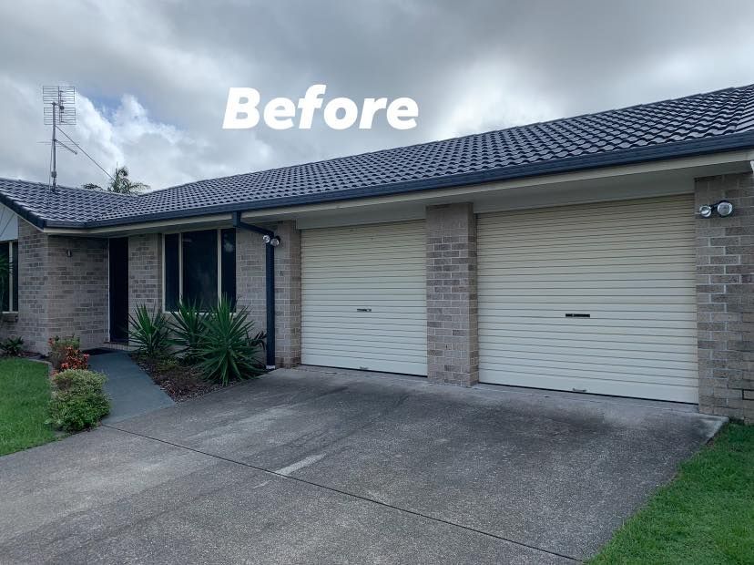 A before picture of a house with two garage doors.
