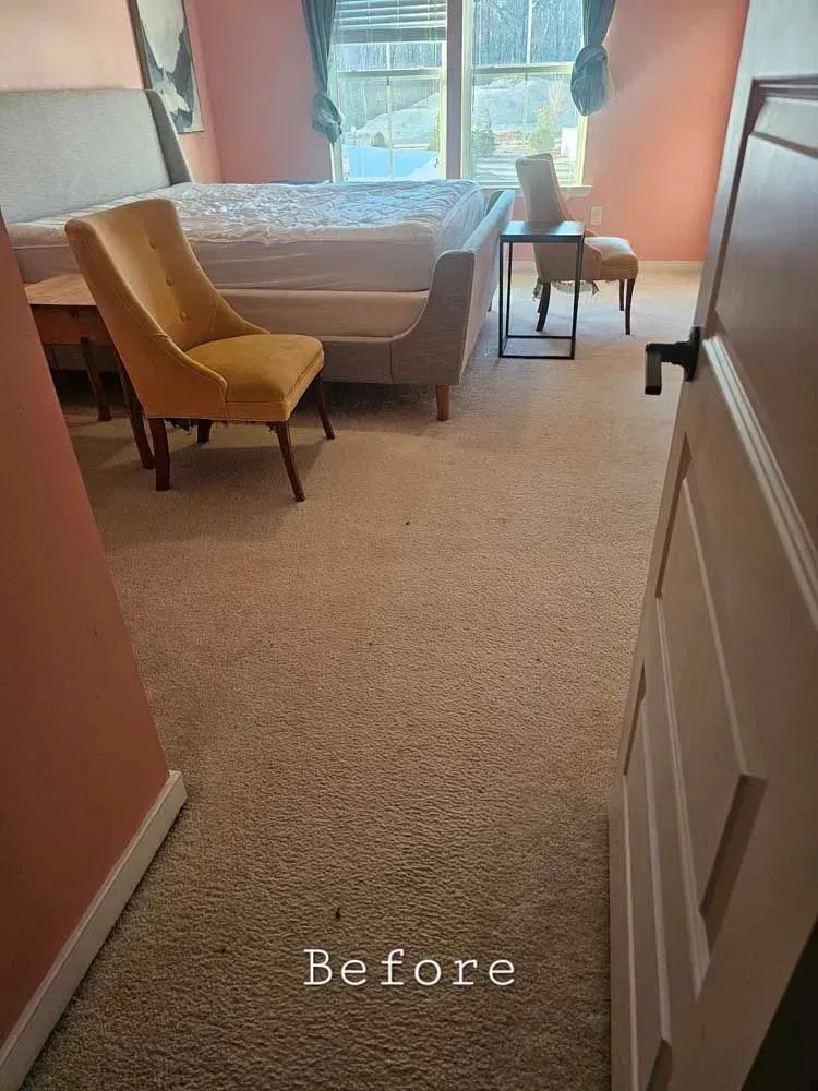 Bedroom with beige carpet, bed, yellow chair, side tables, and pink walls, marked 