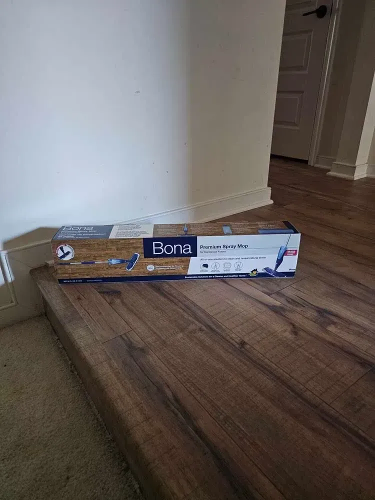 Box of Bona Premium Series Hardwood Floor Mop on wood floor by wall and doorway.