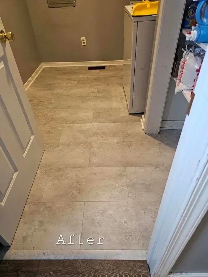 Laundry room with new light gray flooring, seen from a doorway. 