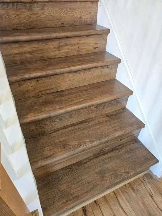 Wooden stairs with a brown finish and white side railings.