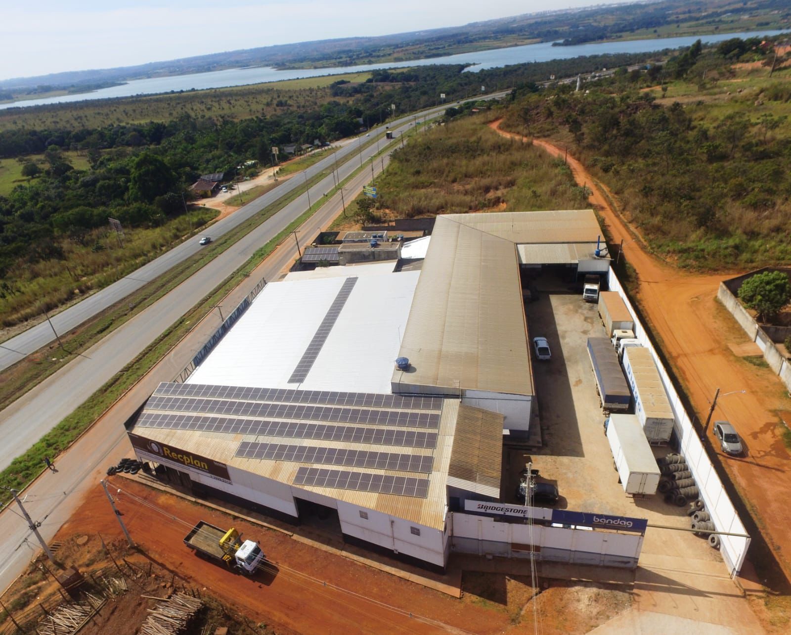 Pneus pendurados em um suporte em uma fábrica, provavelmente para inspeção ou processamento.